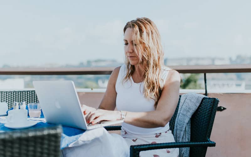 Mujer teletrabajando desde una terraza